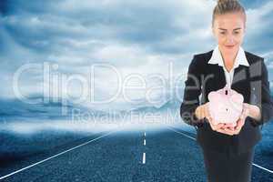 Composite image of businesswoman holding pink piggy bank