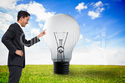 Composite image of smiling asian businessman pointing