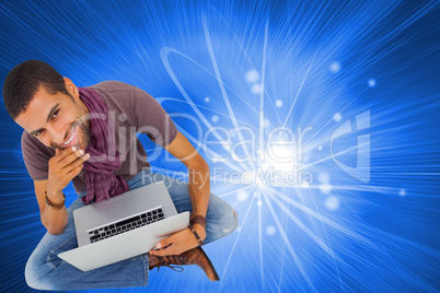 Composite image of thoughtful man sitting on floor using laptop