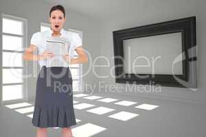 Composite image of shocked stylish businesswoman holding newspap