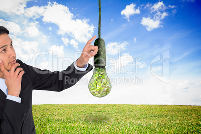 Composite image of thoughtful asian businessman pointing