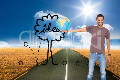 Composite image of handsome man holding out a globe