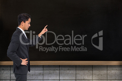 Composite image of unsmiling asian businessman pointing