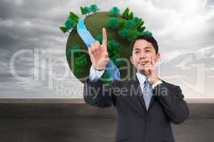 Composite image of thoughtful asian businessman pointing