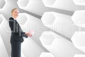 Composite image of businesswoman holding pink piggy bank