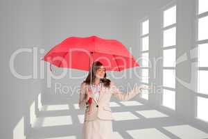 Composite image of attractive businesswoman holding red umbrella