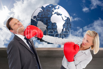 Composite image of businesswoman hitting colleague with her boxi