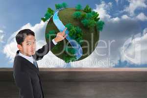 Composite image of serious asian businessman pointing