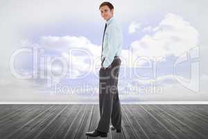 Composite image of smiling businessman standing with hands in po