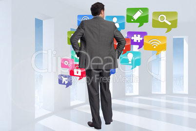 Composite image of businessman with hands on hips