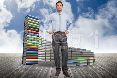 Composite image of serious businessman with hands on hips