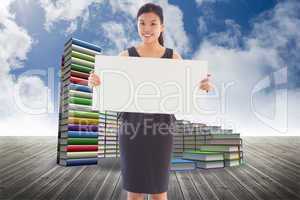 Composite image of businesswoman holding a placard
