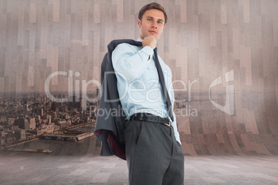 Composite image of serious businessman holding his jacket