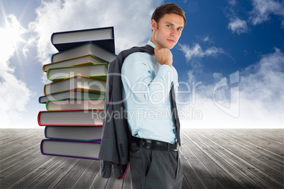 Composite image of serious businessman holding his jacket