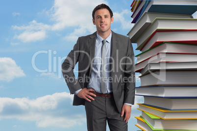 Composite image of smiling businessman with hand on hip