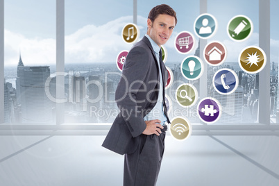 Composite image of smiling businessman with hands on hips