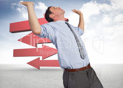 Composite image of businessman standing with hands up