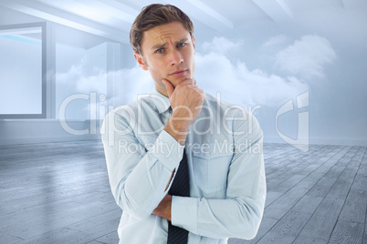 Composite image of thinking businessman with hand on chin