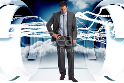 Composite image of serious businessman with hands on hips