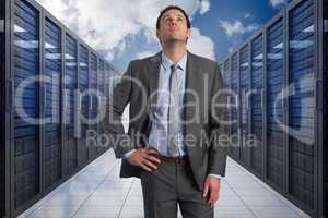 Composite image of serious businessman with hand on hip