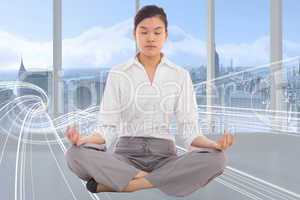 Composite image of businesswoman sitting in lotus pose