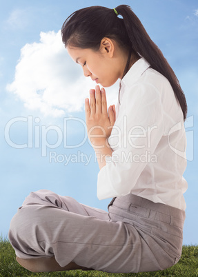 Composite image of businesswoman sitting in lotus pose