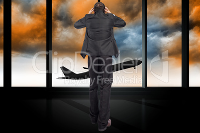 Composite image of stressed businessman with hands on head