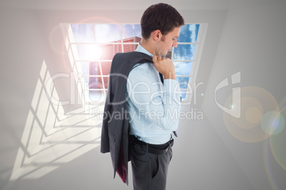 Composite image of serious businessman holding his jacket