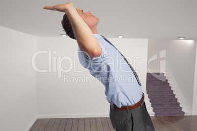 Composite image of businessman standing with hands up