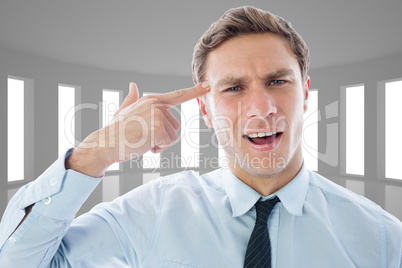 Composite image of businessman making gun gesture