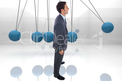 Composite image of cheerful businessman standing with hands on h