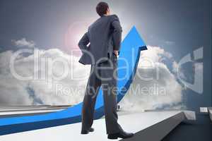 Composite image of businessman standing with hands on hips