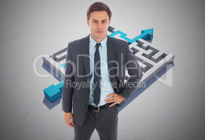 Composite image of serious businessman standing with hand on hip