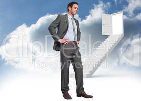 Composite image of smiling businessman with hands on hips