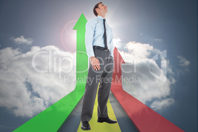 Composite image of happy businessman standing with hands in pock