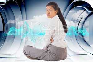 Composite image of businesswoman sitting cross legged frowning