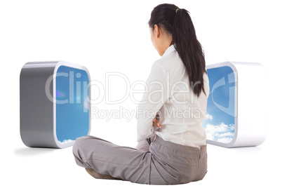 Composite image of businesswoman sitting cross legged
