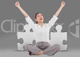 Composite image of cheering businesswoman sitting cross legged