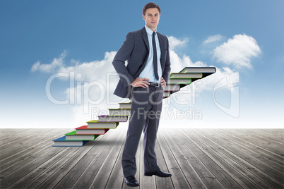 Composite image of serious businessman with hands on hips