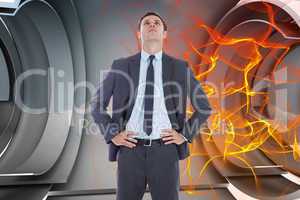 Composite image of serious businessman with hands on hips