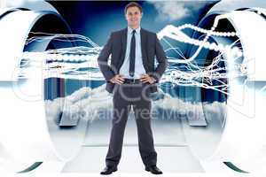 Composite image of smiling businessman with hands on hips