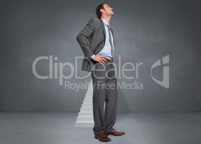 Composite image of smiling businessman with hands on hips