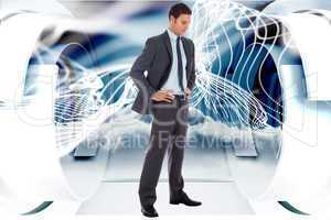 Composite image of serious businessman with hands on hips