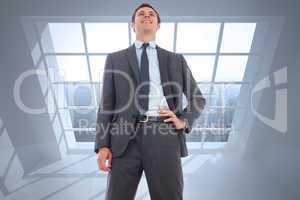 Composite image of cheerful businessman with hand on hip