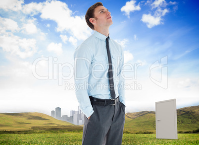 Composite image of serious businessman standing with hands in po