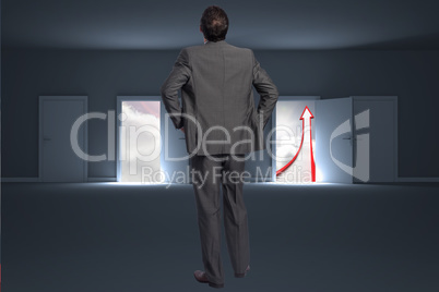 Composite image of businessman with hands on hips