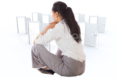 Composite image of businesswoman sitting cross legged