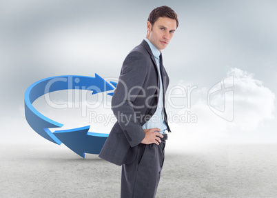 Composite image of serious businessman with hands on hips