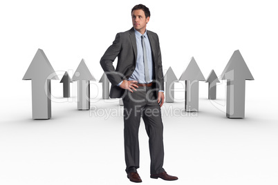 Composite image of serious businessman with hand on hip