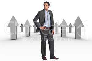 Composite image of serious businessman with hand on hip